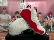 Angled view of the mismatched sneakers displaying a red-paneled shoe beside a blue-accented shoe.
