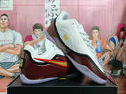 Angled view of white and red basketball shoes with speckled laces and gold accents