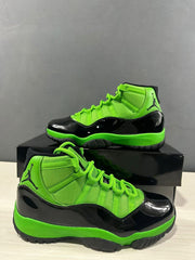 Close product view of the green mesh upper, glossy black mudguard, and black outsole.
