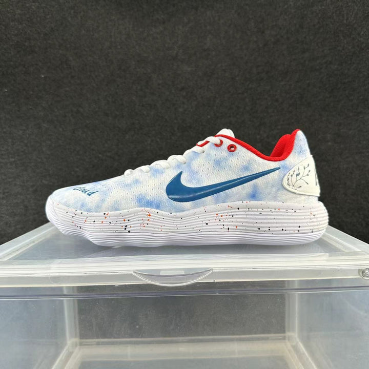 Side view of a white and pale-blue Nike low-top shoe with a blue Swoosh, red lining, and speckled white sole.
