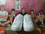 Pair of white sneakers with silver accents viewed from the front