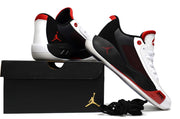 White, black and red Luka.77 sneakers arranged with a black shoebox and spare black laces.