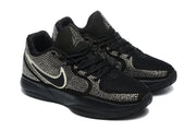 Angled front view of the pair of black Nike sneakers with lace-up closure, mesh toe areas, and silver rhinestone-style embellishment.