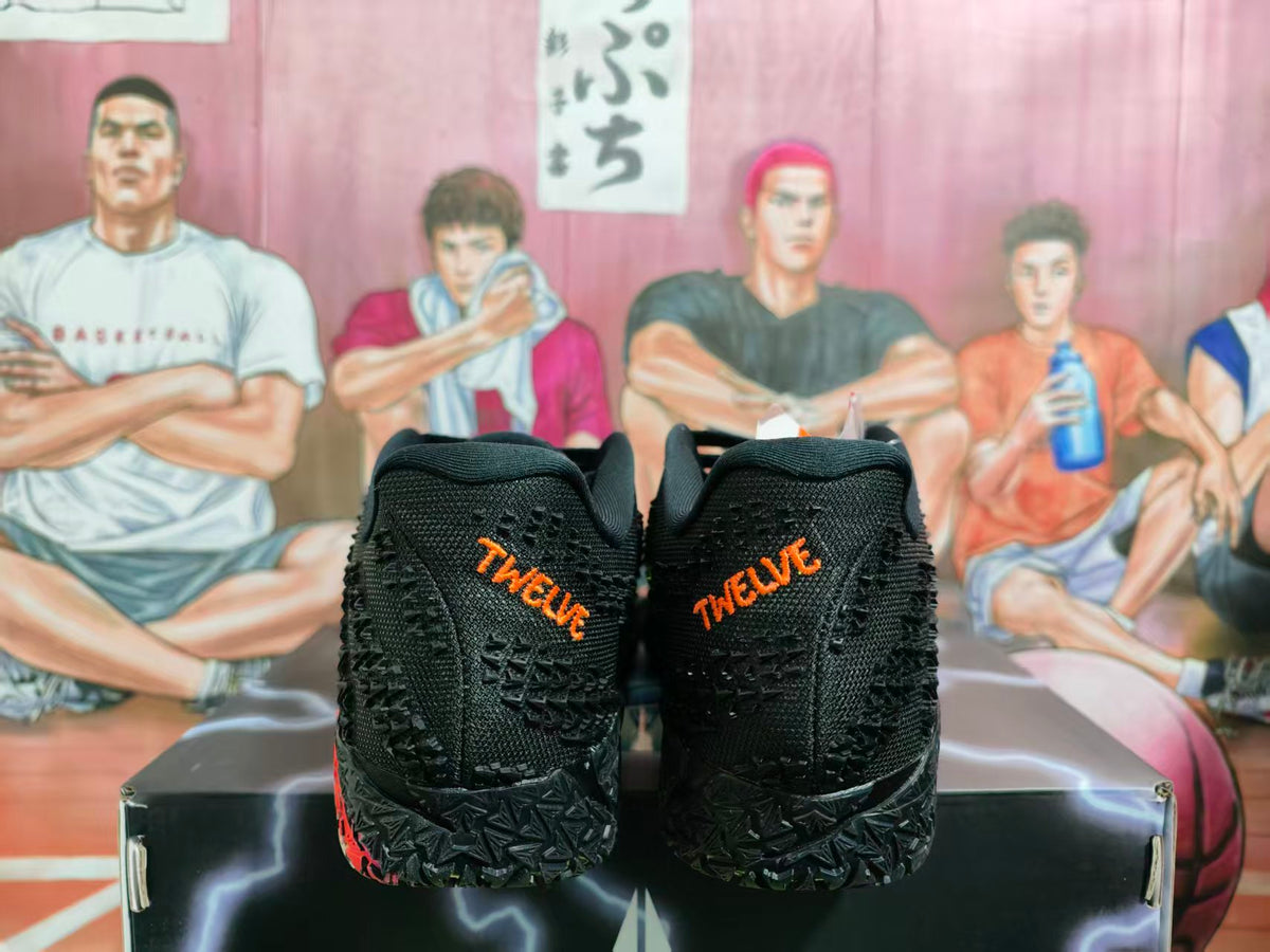 Rear view of black Nike sneakers with textured uppers, orange heel lettering, and patterned black outsoles on a shoebox.