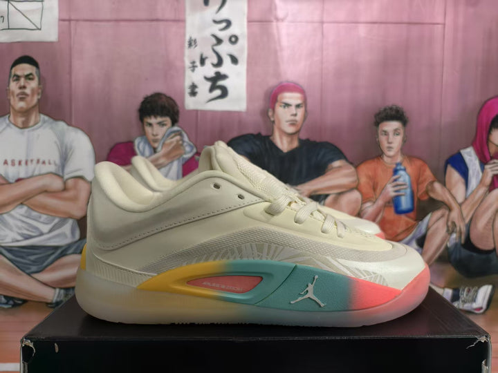 Side view of beige Jordan basketball sneakers showing layered panels, lace-up closure, Jumpman logo, and multicolor sole accents on a black shoebox.