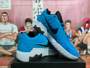 Angled view of blue Nike basketball sneakers displaying the side branding, layered upper, white midsoles, and textured outsole.
