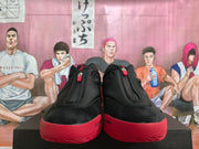 Front view of the pair showing the black uppers, central zippers, padded collars, and red toe sections.