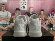 Rear view of the white Nike sneakers showing padded collars, heel panels, and green vertical heel accents.