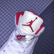 Close-up of the padded tongue with red Jordan branding, white laces, and a clear lace toggle.