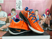 Angled view of orange and blue Nike basketball shoes with black side panels
