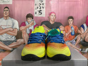 Front view showing the matching pair of colorful basketball sneakers with blue laces and yellow toe boxes.