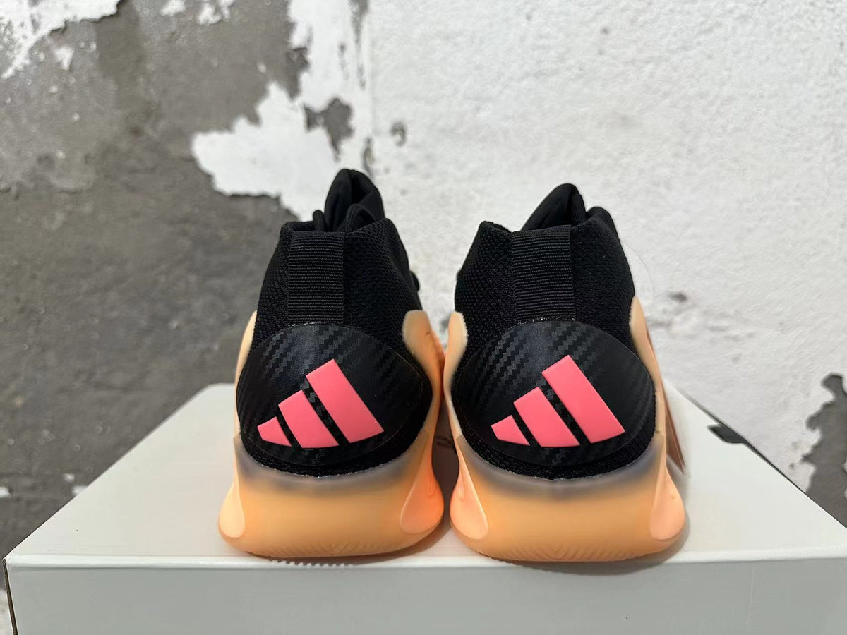Rear view of black Adidas AE 1 basketball shoes with pink heel accents and peach-orange soles.