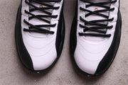 Close-up of the white toe boxes and black laces on a pair of Air Jordan 12 sneakers