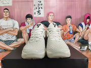 Front view of the white and light gray basketball sneakers showing the laces and tongue logos.