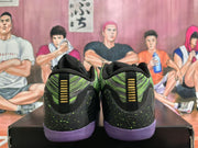 Rear view of black and green Nike Kobe basketball shoes with purple outsoles and gold heel details.
