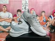 Angled view of grey Nike basketball sneakers displayed one over the other, showing the side swoosh, heel detail, lace-up construction, and patterned outsole.