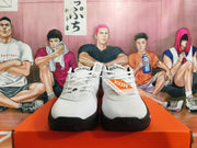 Front view of white Nike basketball shoes with black outsole accents