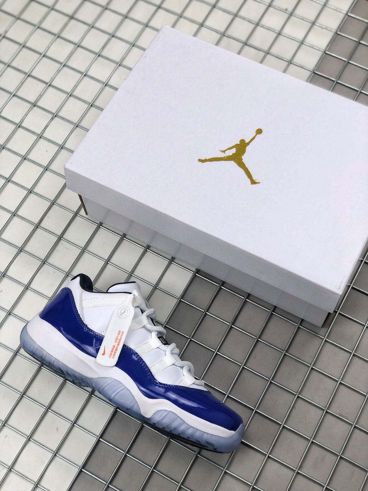 Blue and white Jordan sneaker beside a white Jordan shoebox.