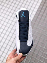 Top view showing the black tongue, black laces, white side panels, and blue Jordan branding.