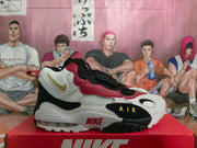 Side view showing the layered Nike sneaker upper, gold-toned side branding, AIR detail, and visible heel air unit.