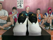 Front view of white and black Jordan basketball sneakers with black tongues and gold logos