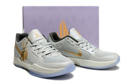 Light gray and gold Nike Ja 2 shoes displayed in front of a shoe box