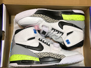 Top-down view of the pair placed inside an open shoebox, showing the patterned panels and contrasting midsoles.