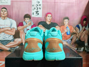 Rear view of the turquoise sneakers showing padded collars, gold-toned heel panels, and visible signature-style graphics.