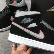 Close-up of the grey and red-edged Swoosh, black upper and Air Jordan Wings branding.