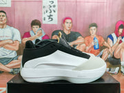 Side view of a black and white Jordan basketball shoe with a sculpted white sole