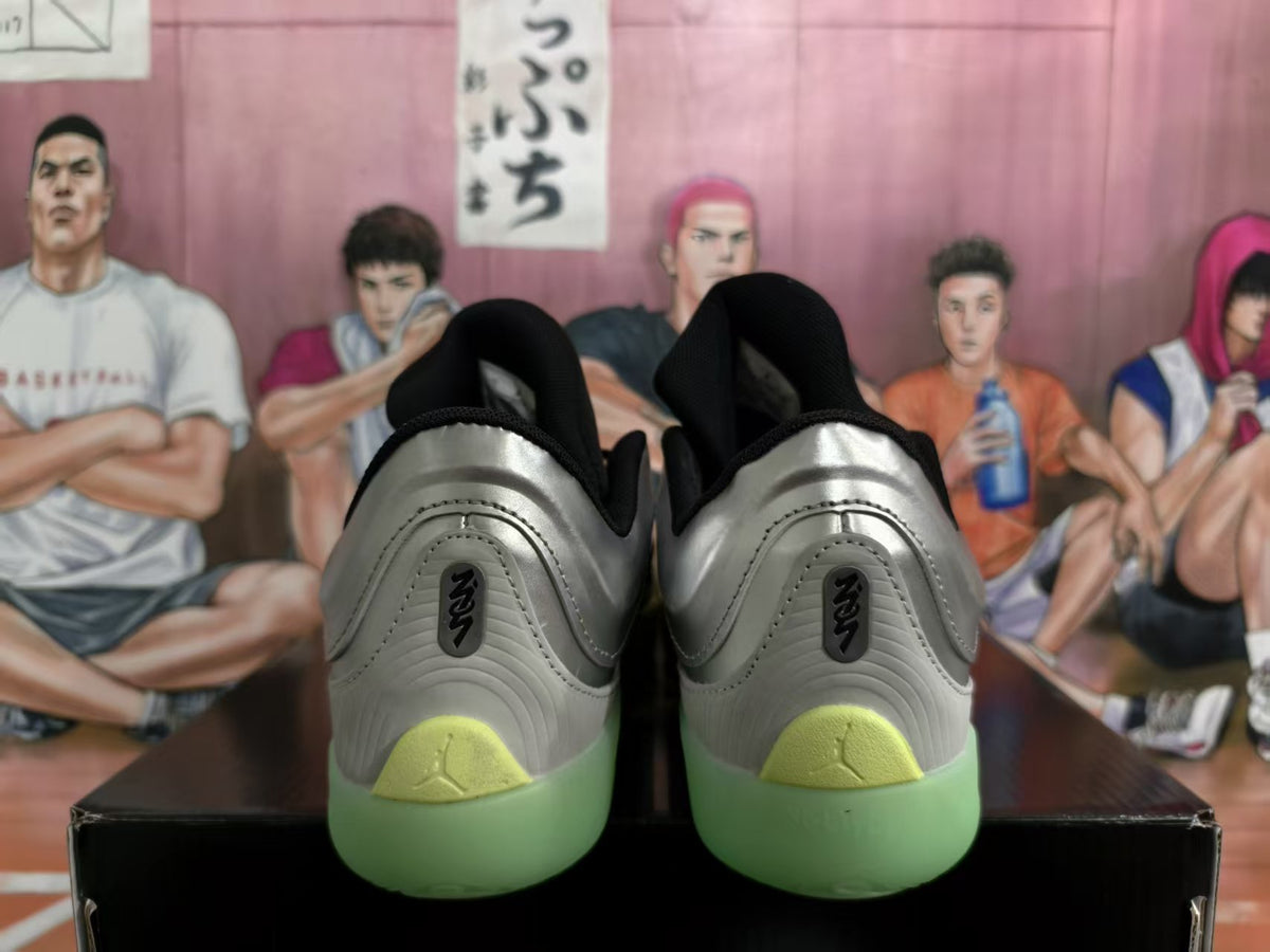 Rear view of silver and black Jordan basketball sneakers showing Jumpman heel branding and translucent pale green soles.