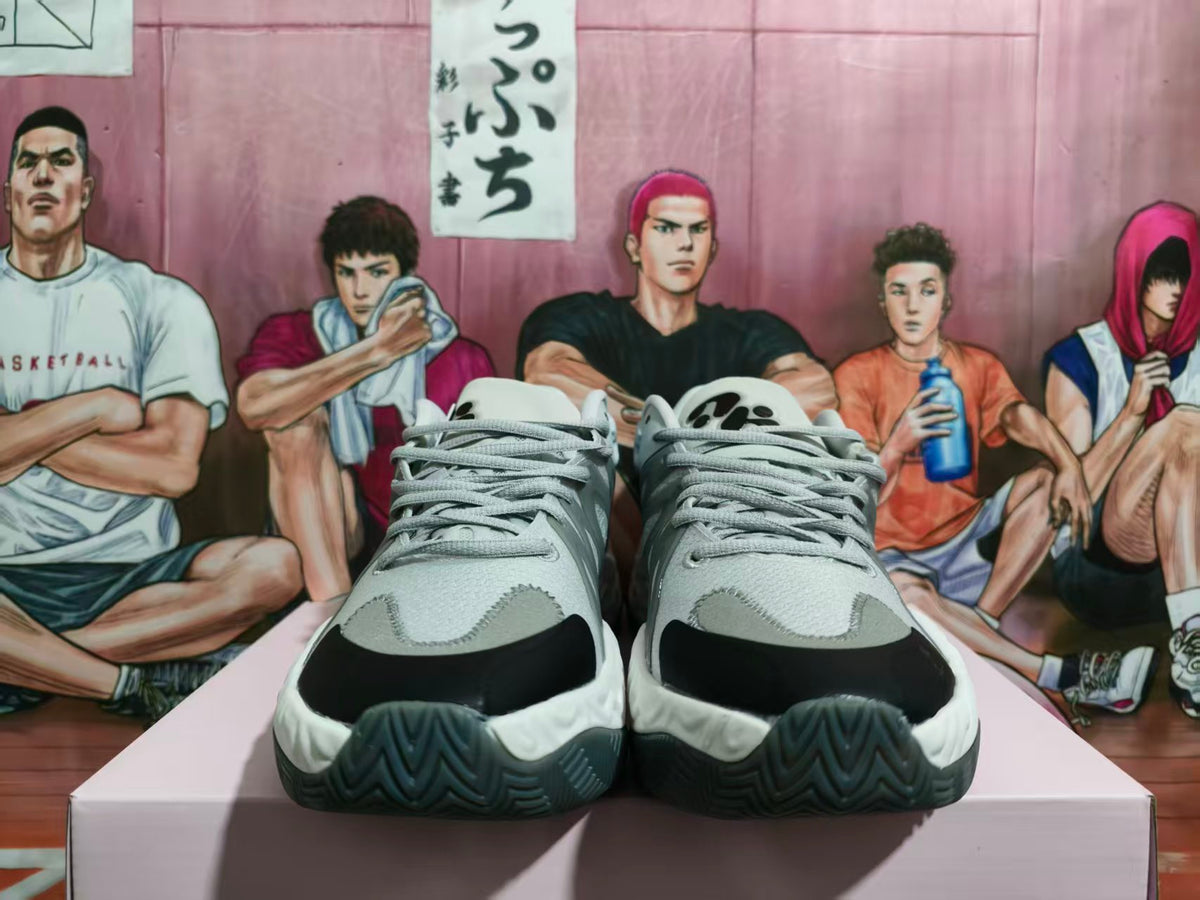 Front view of gray and white lace-up basketball sneakers with black toe accents