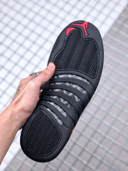 Bottom view showing the black outsole with patterned traction sections and red Jordan details.