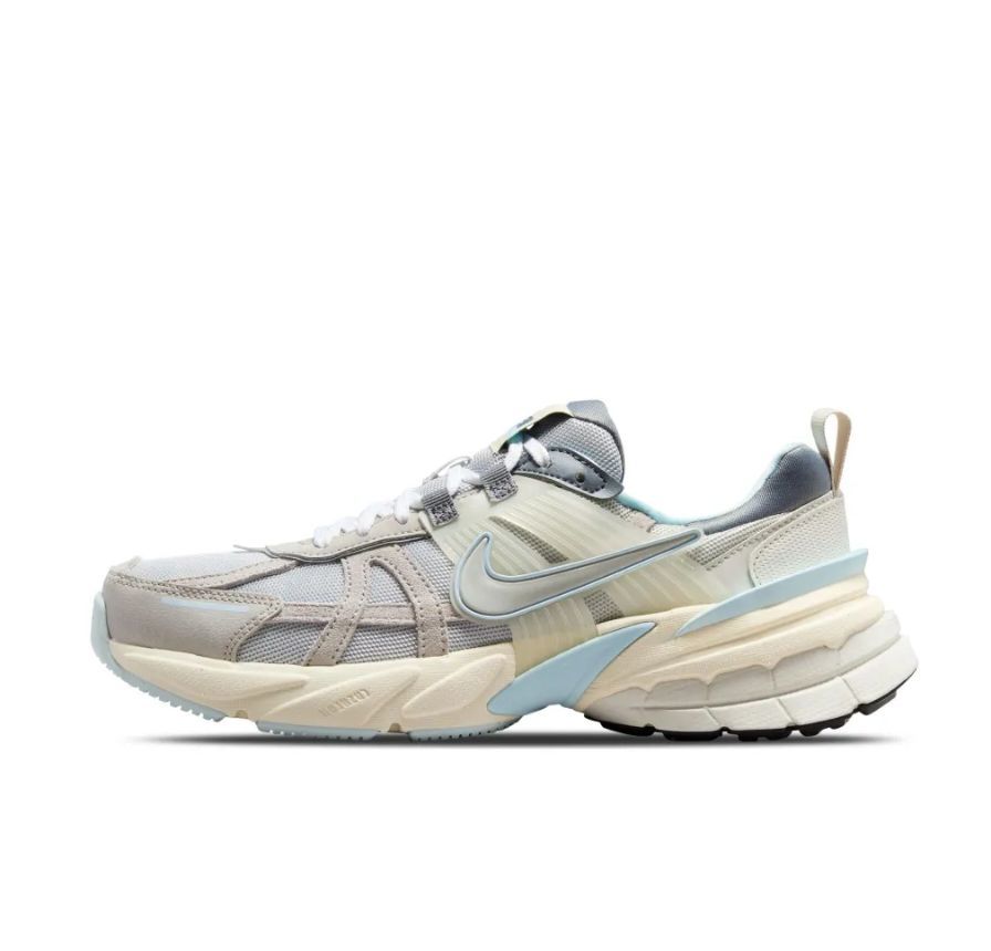 Side view of a light grey Nike V2K Run sneaker with layered panels, white laces, a Swoosh, and a chunky sole