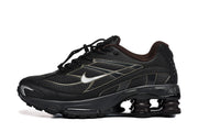 Side view of a black Nike Shox Ride 2 sneaker with mesh panels, a contrasting Swoosh, and spring-shaped heel elements.