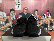 Front view of black Nike basketball shoes with black laces and contrasting pale outsole details.