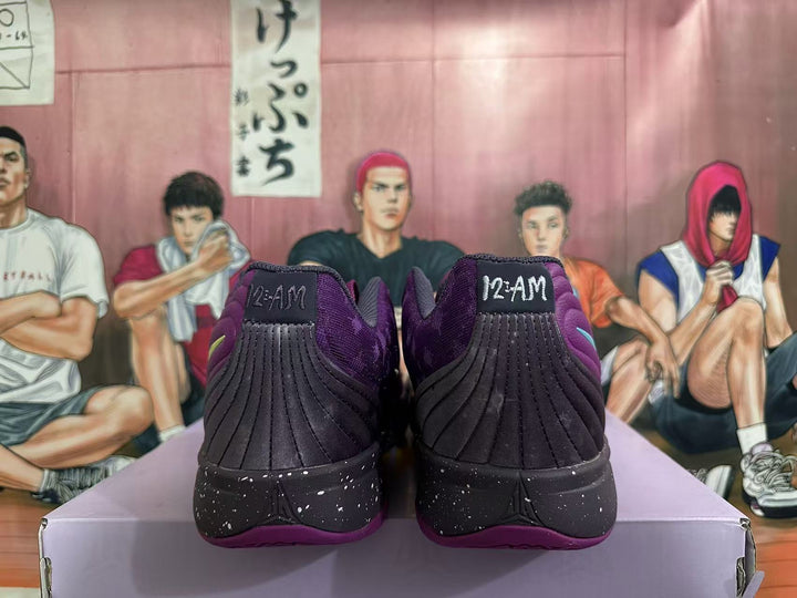 Rear view of purple Nike basketball shoes with dark speckled midsoles and “12-AM” heel tabs.
