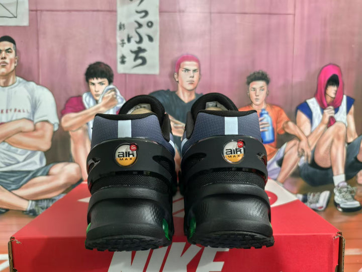 Rear view of Nike Air Max sneakers showing black heel panels, Air Max branding and green outsole cushioning units.