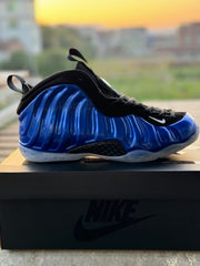 Blue and black high-top Foamposite-style sneaker with a translucent outsole, photographed on a Nike shoebox.
