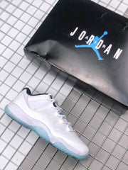White Jordan Air Jordan 11 Low sneaker shown beside a black Jordan-branded shoe box.