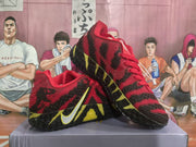 Angled view of the pair highlighting the red upper, black overlays, yellow outsole accents, and side swoosh.