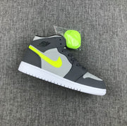 Side view of a grey and charcoal Jordan mid-top sneaker with fluorescent volt branding, white outsole and an extra fluorescent lace set.