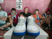 Front view of gray and white basketball sneakers with blue soles, white laces, and multicolor dot detailing.
