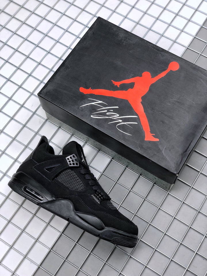 Black Jordan Air Jordan 4 sneaker beside a black Jordan shoebox.