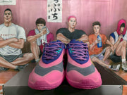 Front view of the Nike basketball shoes showing pink laces, turquoise accents and dark gray toe panels.