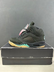 Side profile of a dark green Jordan Air Jordan 5 sneaker with perforated paneling, black midsole, and aqua accent detail.