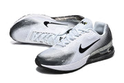 Angled view of white Nike sneakers with black dotted detailing and visible heel units.