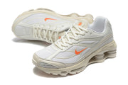 Pair of light-colored Nike Shox Ride 2 sneakers shown from angled side and front views.