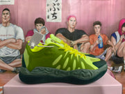 Side view of a green basketball sneaker with yellow laces and dark sole