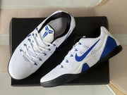 Angled top view of the Nike Kobe 9 sneakers showing the tongue logos, lacing and blue heel panels.